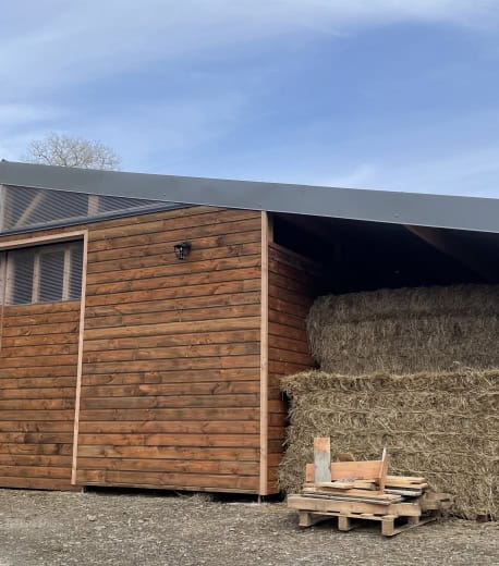 Grange en bois avec stockage de foin pour ferme ou exploitation agricole.