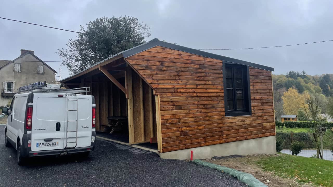 Balcon en bois avec structure ouverte et toiture en pente.